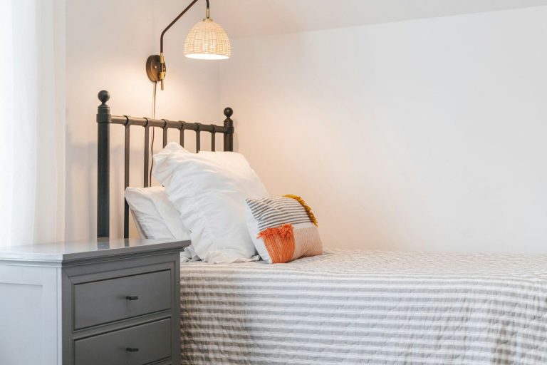 Ein einfaches Schlafzimmer mit einem Bett, Kissen und einem Nachttisch bei AirBnB